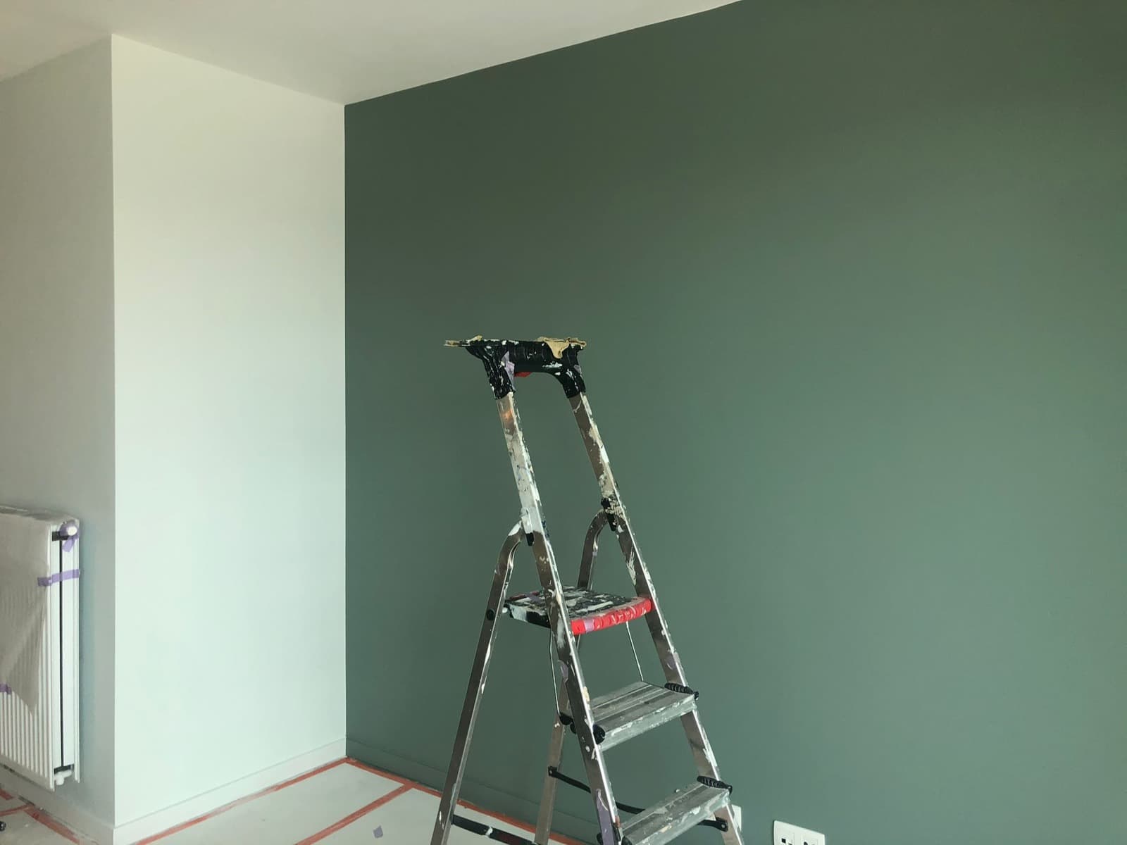 Mur d'appartement haut standing peint en vert sapin avec finition double couche